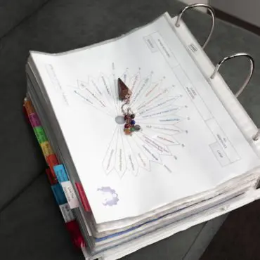 A binder with many different colored tabs on it.