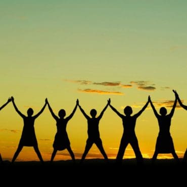 seven people standing in a row with hands in hands