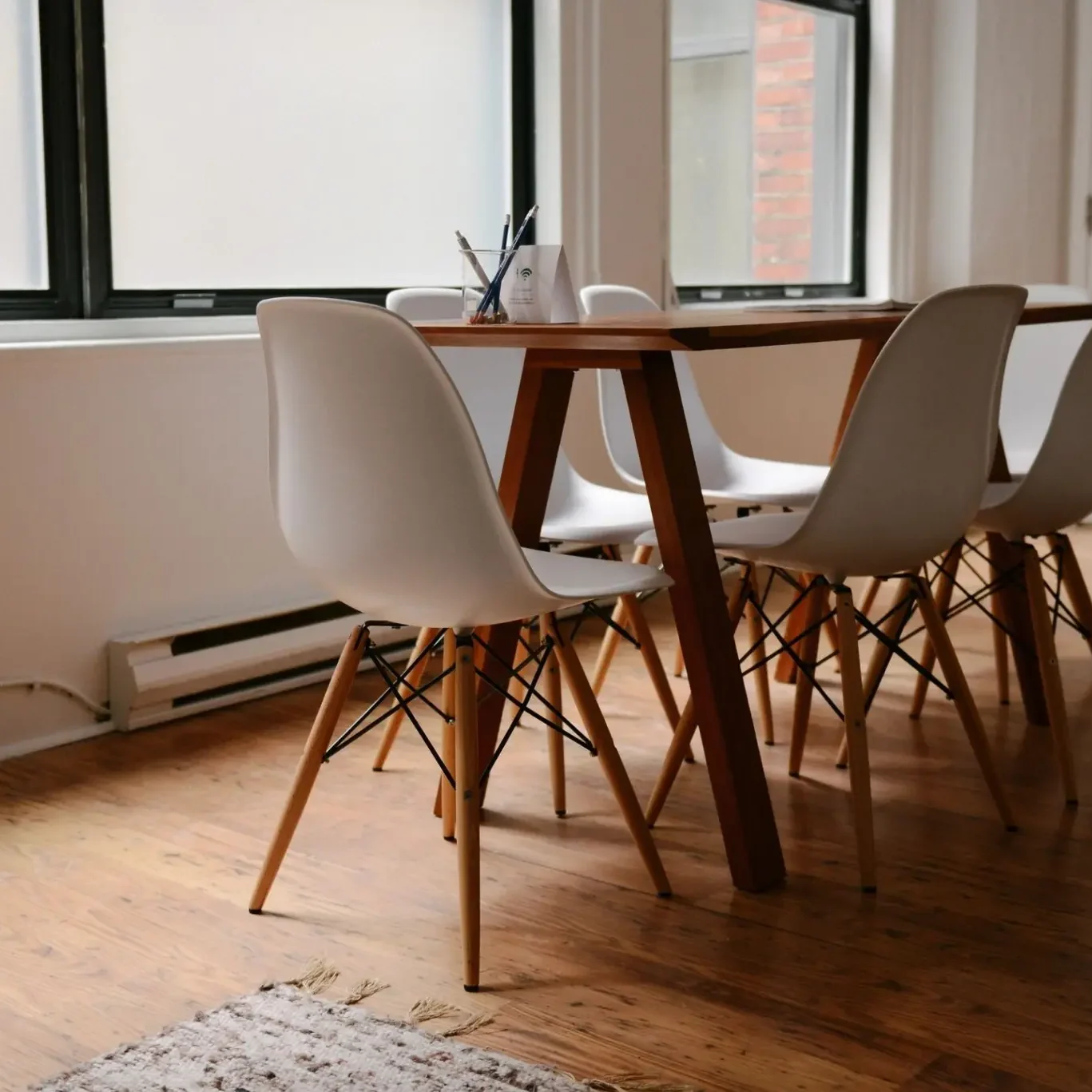 Minimalist wooden table with four white chairs